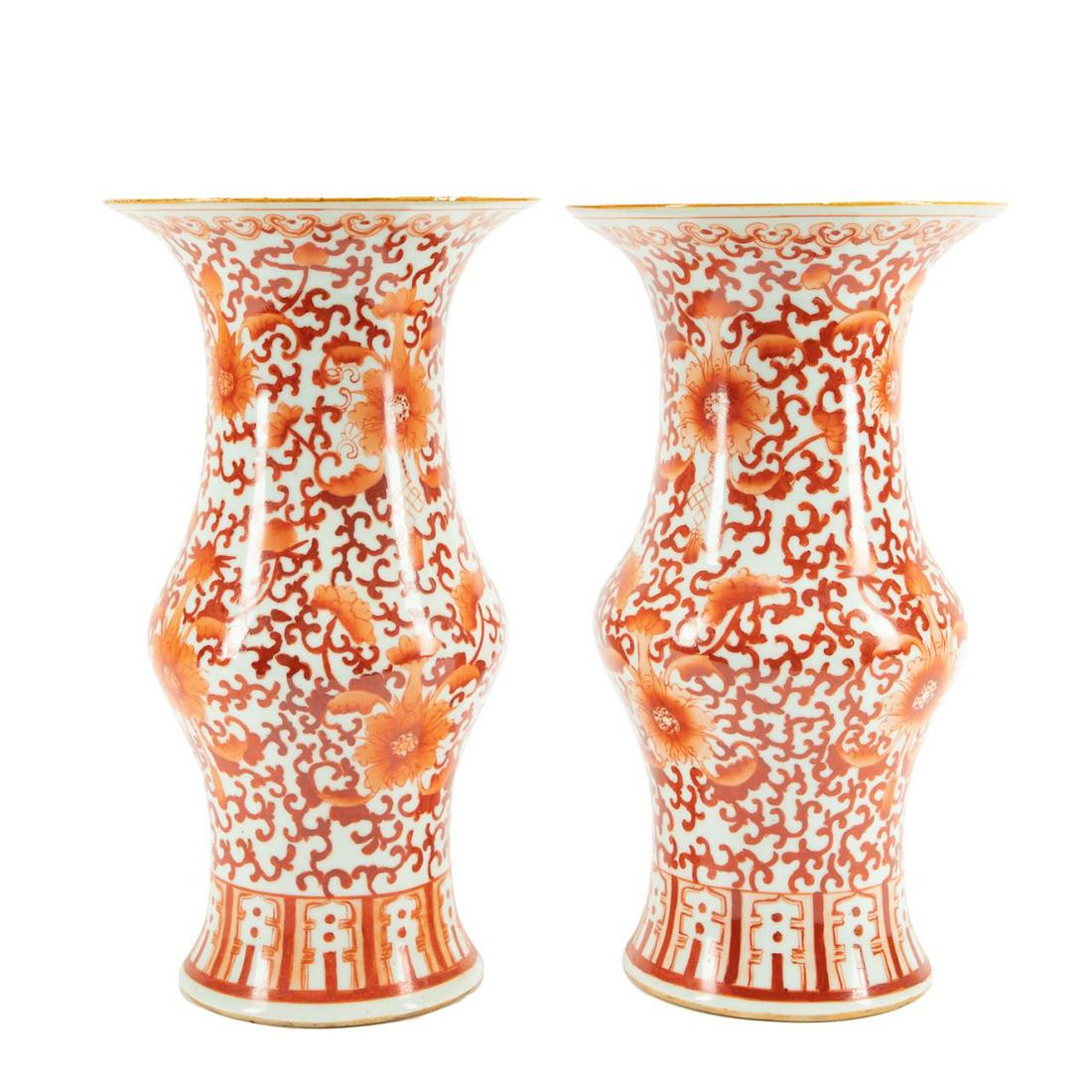PAIR CHINESE IRON-RED PORCELAIN GU VASES: Pair of Chinese iron-red porcelain gu vases decorated with ruyi head bands at the rims, having scrolling lotuses, eternal knots, and lappets at the feet, apparently unmarked. Approximate dimensions: h
