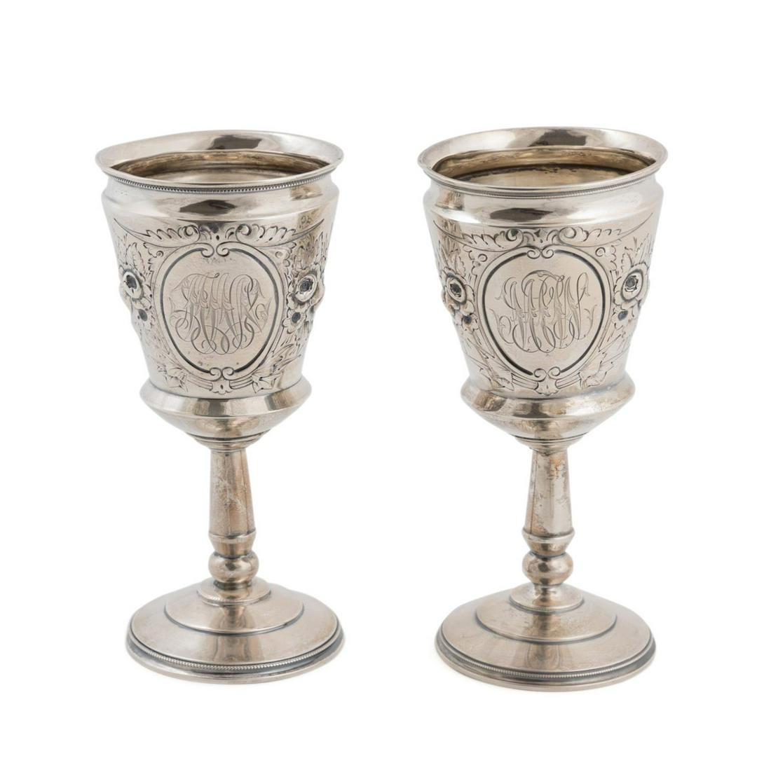 PAIR 19TH C. WOOD & HUGHES STERLING SILVER GOBLETS: Pair of mid-19th century Wood and Hughes, New York sterling silver goblets, having floral repousse framing a cartouche with monogram, rising on a tapering standard and circular foot, marked 'W & H Ste
