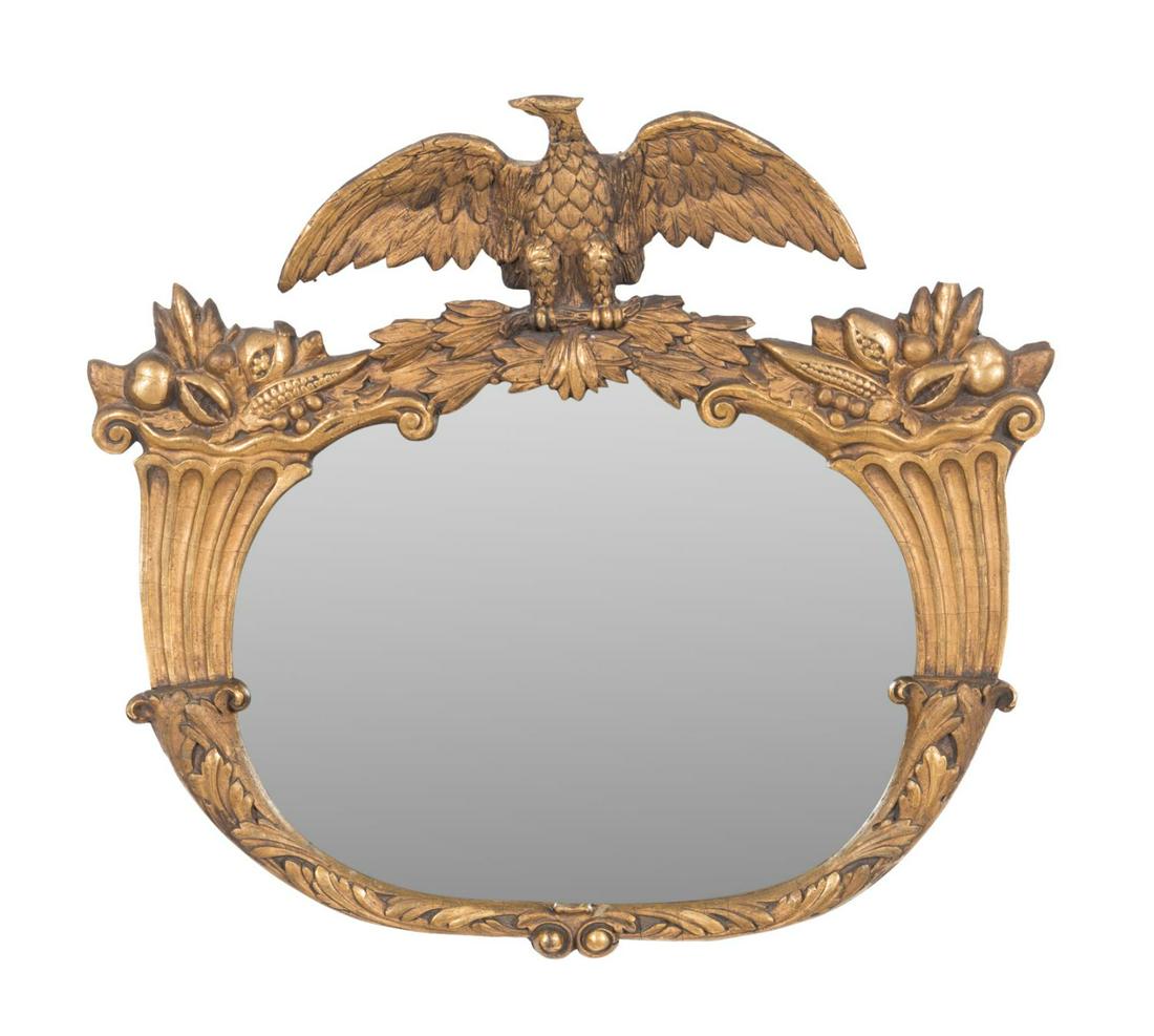 FEDERAL STYLE EAGLE CORNUCOPIA MIRROR, C. 1900: American giltwood and composition oval mirror in the Federal taste, circa 1900, having an eagle crest flanked by cornucopias, apparently unmarked. Approximate dimensions: h. 23. 5", w. 26. 25", d. 5".