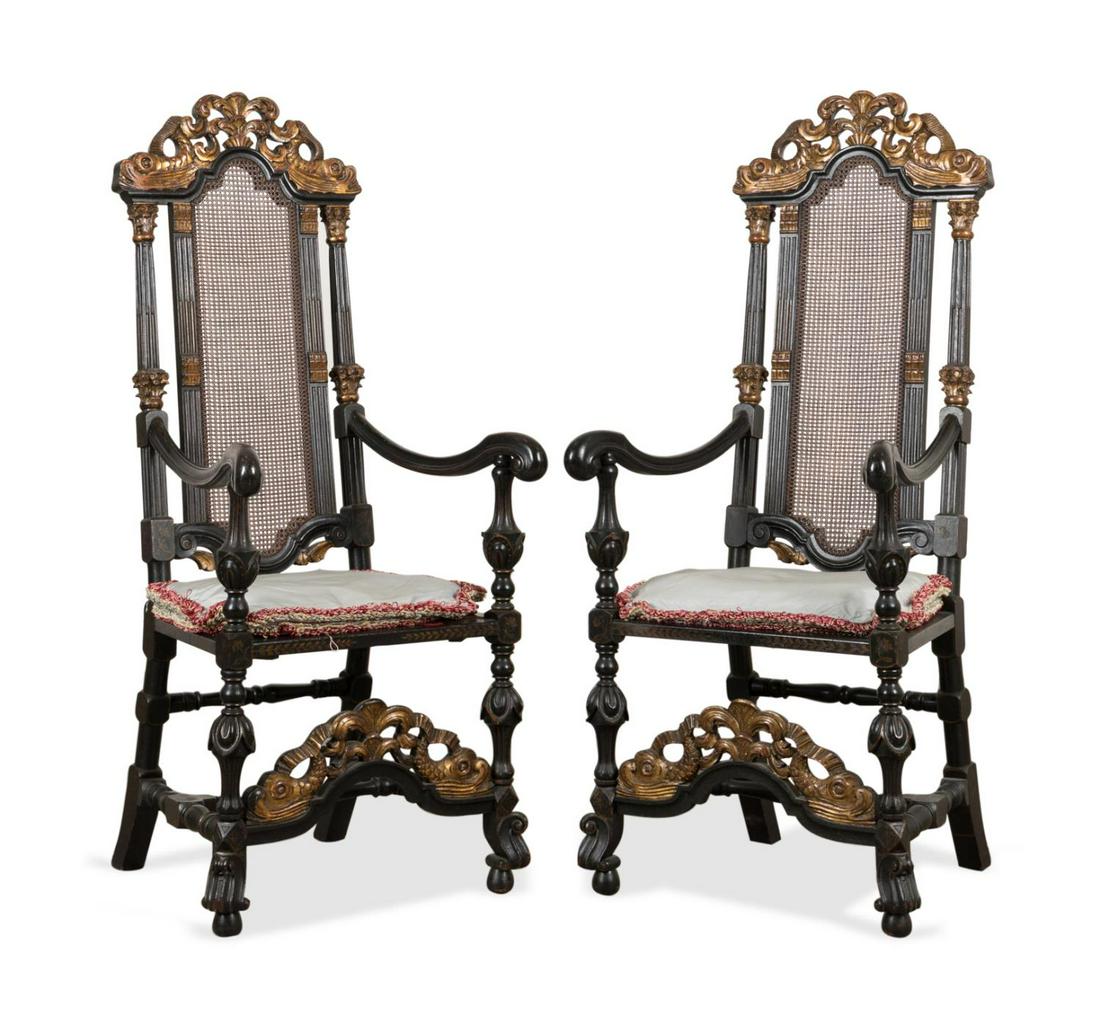 PAIR WILLIAM & MARY STYLE EBONIZED CANED ARMCHAIRS: Aimone Manufacturing Company (American c. 1870-1919), ebonized and parcel gilt armchair in the William and Mary Baroque taste, early 20th century, each having a scrolled pierced dolphin crest and stre