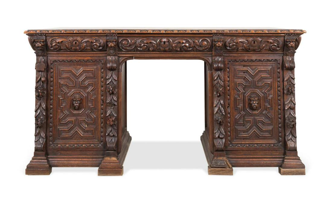 19TH C. RENAISSANCE REVIVAL OAK KNEEHOLE DESK: American or English Renaissance Revival carved oak desk, having an egg and dart edged top, three foliate carved drawers, two strap work paneled doors with cartouche concealing seven drawers, flanking 