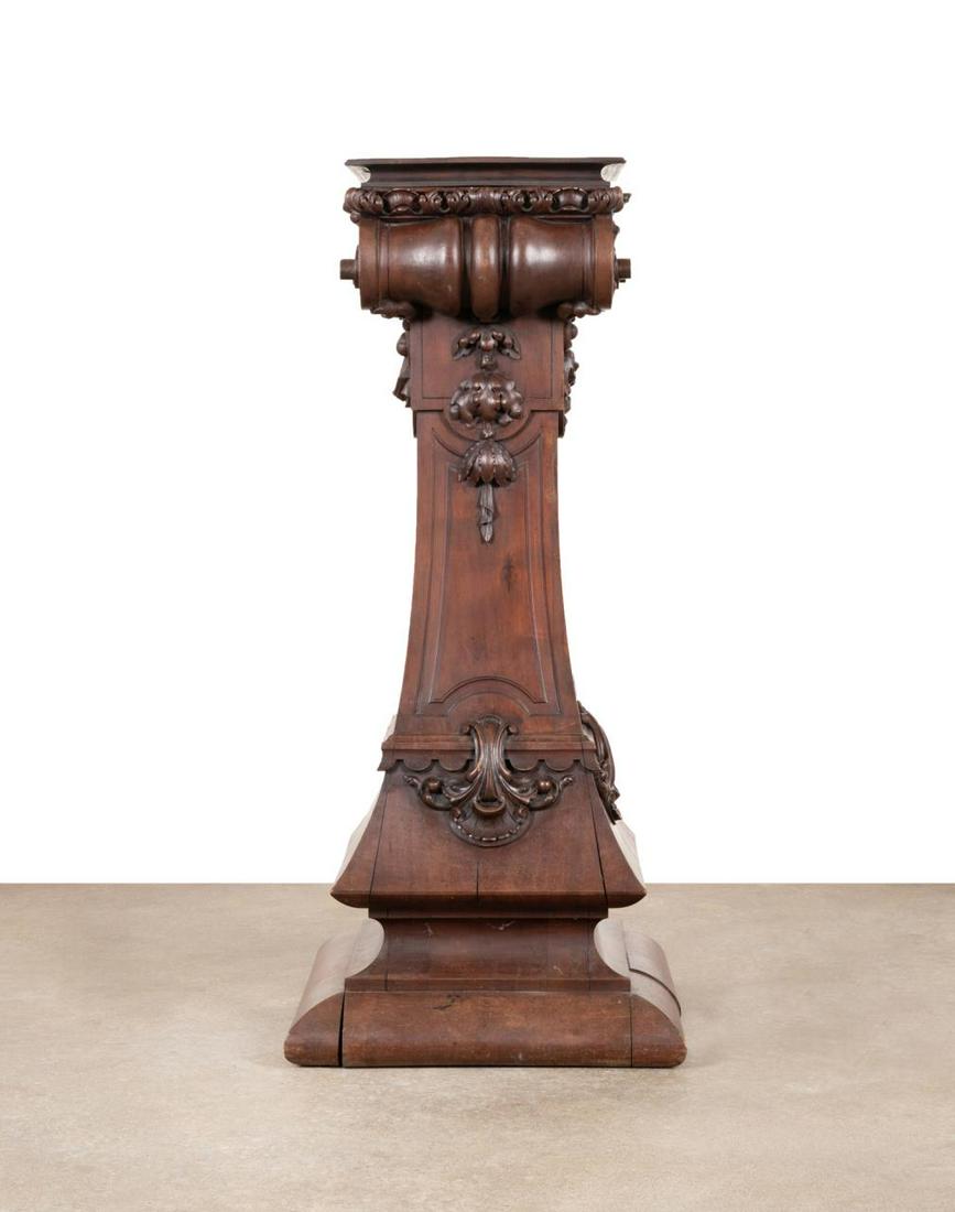LARGE RENAISSANCE REVIVAL CARVED WALNUT PEDESTAL: Large American or European Victorian Renaissance Revival carved walnut column form pedestal, last quarter 19th century, having a draped Ionic capital on an ogee plinth, apparently unmarked. Approximat