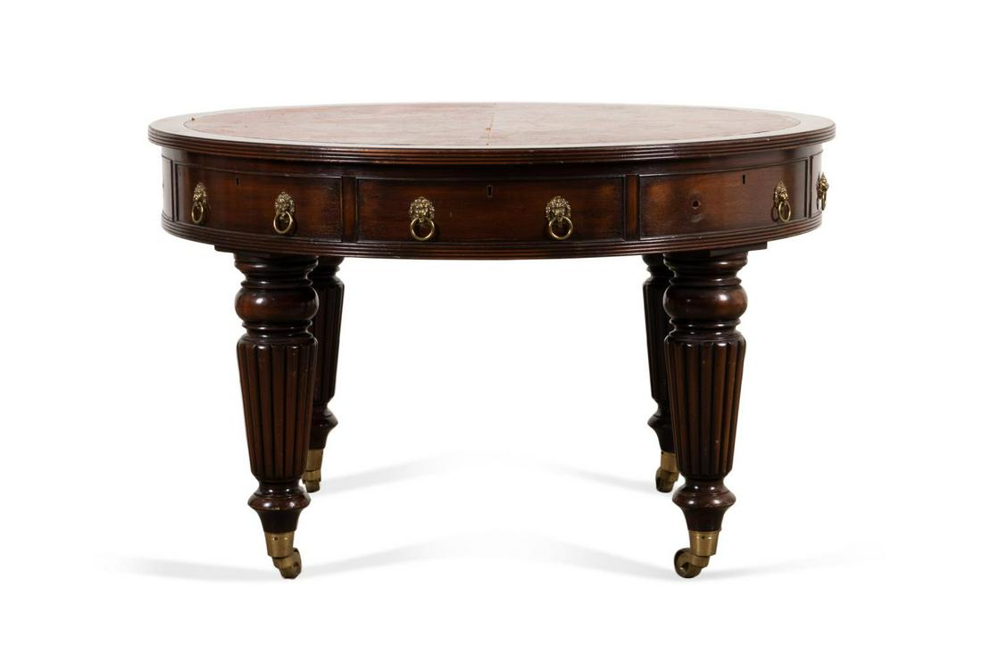 19TH C. WILLIAM IV MAHOGANY CENTER TABLE: English William IV/Victorian mahogany center table, 19th century, having a tooled leather top, eight faux frieze drawers with brass lion's head pulls, and rising on tapering reeded legs with casters, 