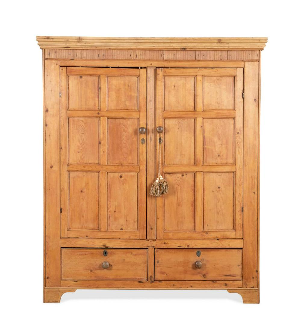 19TH C. GEORGIAN STYLE PINE TWO DOOR WARDROBE: Irish pine wardrobe in the Georgian taste, 19th century, having a shaped cornice and double paneled door above two drawers, rising on bracket feet, apparently unmarked. Approximate dimensions: h. 74. 