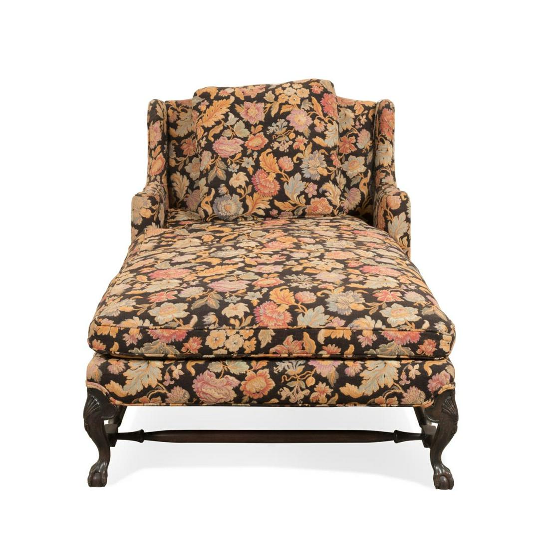 QUEEN ANNE STYLE FLORAL UPHOLSTERED CHAISE LOUNGE: Wingback chaise lounge in the Queen Anne taste, having floral upholstery, lose back and seat cushions, and rising on cabriole legs with stretcher and claw and ball feet, apparently unmarked. Approxima