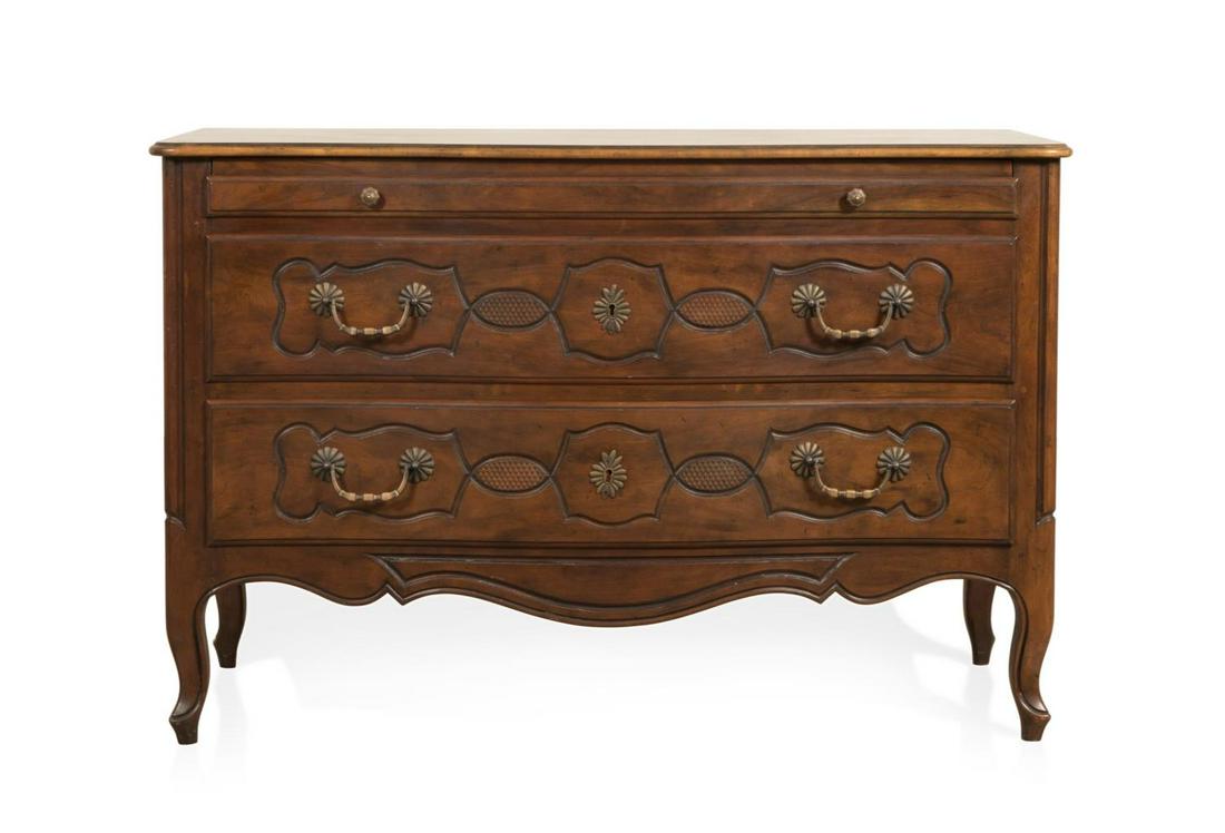BAKER FRENCH PROVINCIAL STYLE WALNUT COMMODE: Baker Furniture walnut commode in the provincial Louis XV taste, having an overhanging top, one short drawer above two deeper drawers, and rising on front cabriole legs with die feet, manufacturer's p