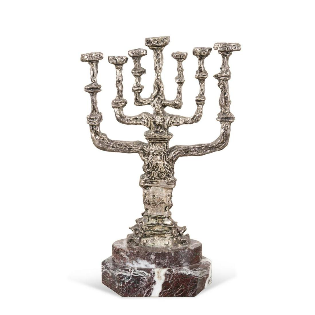 SALVADOR DALI SILVERED BRONZE MENORAH ON MARBLE: Salvador Dali (Spanish, 1904-1989), silvered bronze tree form menorah, the candle cups with Hebrew inscriptions, and stem having the head of Moses above a Star of David, on a stepped brown marble base