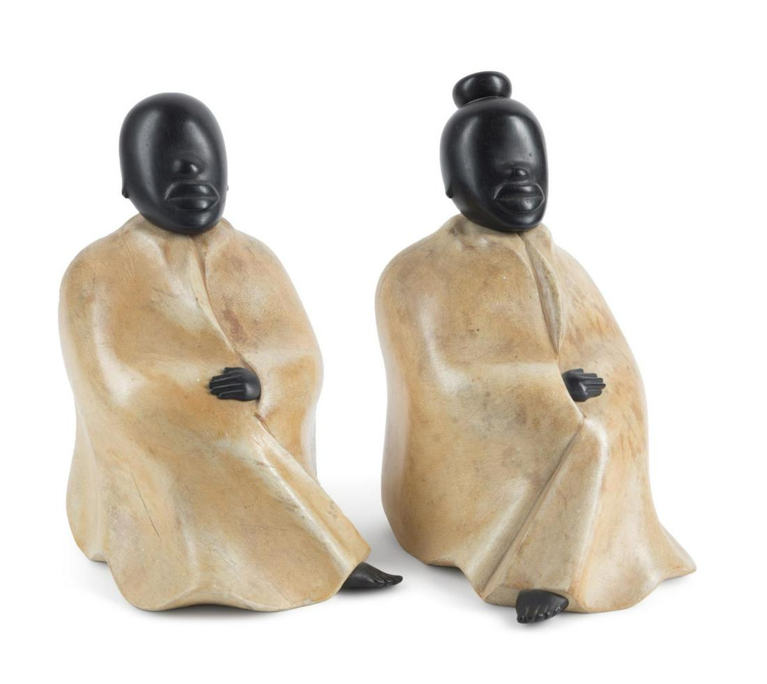 PAIR OF ALDO TURA SEATED MALE AND FEMALE FIGURES: Pair of Aldo Tura (Italian 1909-1963) wooden figures, mid-20th century, modeled as a seated male and female, each wearing robes with ebonized head, hands and feet, stamped marks and foil label to the