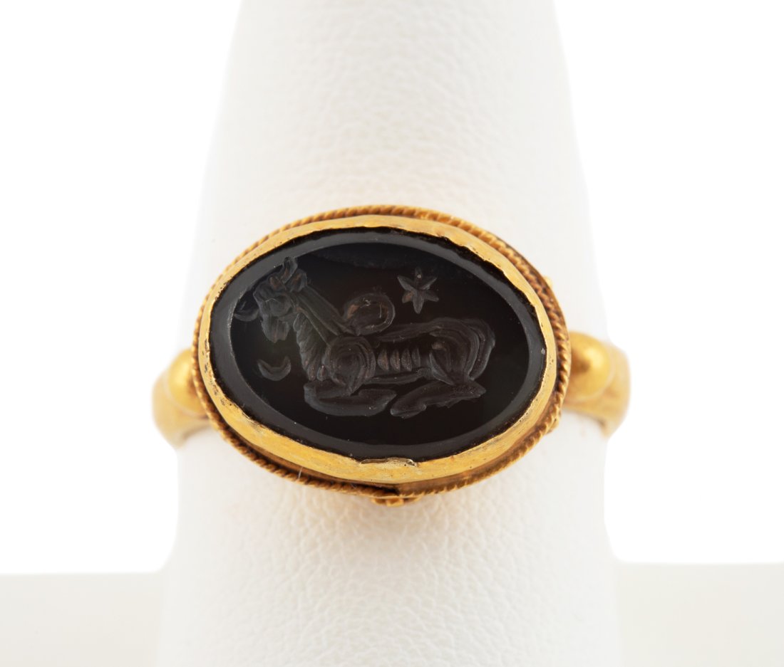 20K YELLOW GOLD & GRAY CARNELIAN INTAGLIO RING: Handmade 20k yellow gold intaglio ring with an engraved greyish-brown oval carnelian tablet featuring a resting horse. Tested as 20k gold quality. Approximate dimensions: US ring size 9; total weight 