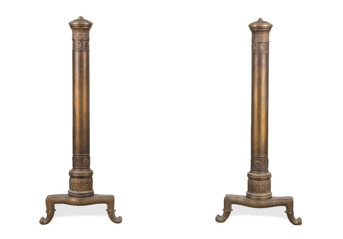 FRENCH BRONZE NEOCLASSICAL STYLE COLUMNAR ANDIRONS: Pair of French bronze Neoclassical style columnar andirons, late 19th or early 20th centuries, having a molded acanthus capital rising on a cylindrical standard, resting on wrought iron feet. Approxim