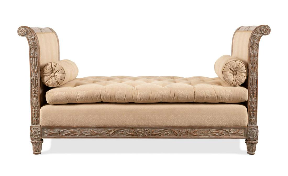 FRENCH NEOCLASSICAL STYLE WHITE WASHED DAYBED: French carved wooden white washed daybed in the Louis XVI Neoclassical taste, having curved end panels with fasces crests, foliate decoration, loose cushion with two bolsters, and rising on acanthus f