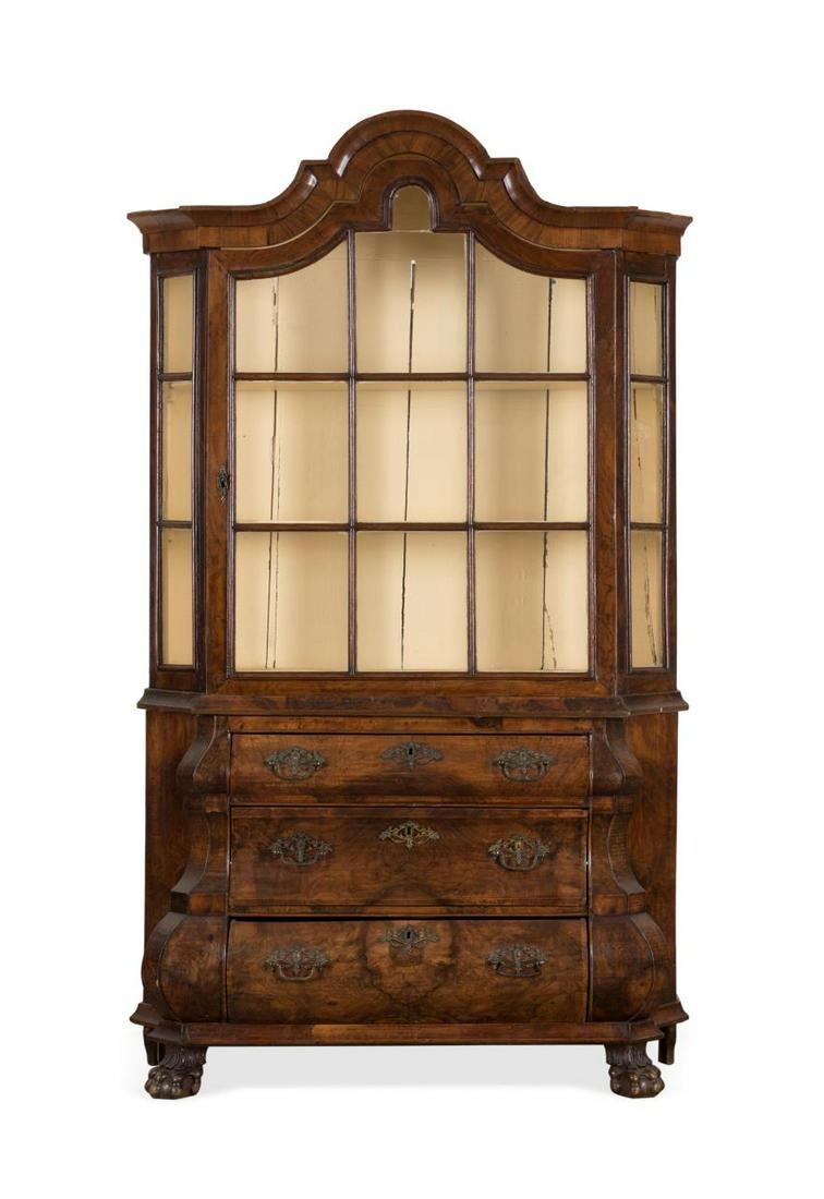 DUTCH BAROQUE WALNUT VENEER VITRINE ON CHEST: Dutch Baroque style walnut veneer vitrine cabinet on bombe chest, 19th century, having a shaped cornice, glazed door cabinet with fabric lined shelves, over a three drawer bombe chest and rising on pa