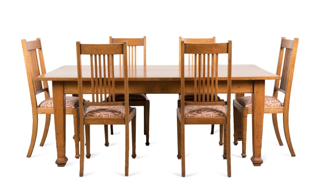 7PC ARTS & CRAFTS OAK DINING ROOM SET, 1910-1911: Seven piece British Arts and Crafts oak dining room set, early 20th century, comprising six side chairs with vertical open splats, drop in seats with William Morris & Co. "Willow Boughs" upholstery, a