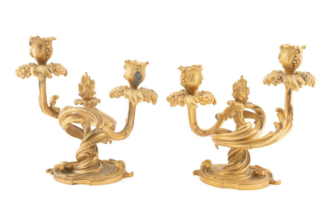 PAIR 19TH C. LOUIS XV STYLE GILT BRONZE CANDELABRA: Pair of Louis XV style gilt bronze candelabra, 19th century, each having a flame finial and two sinuous acanthus arms terminating to leaf and berry candle cups, rising on a 'C' scroll bases and having