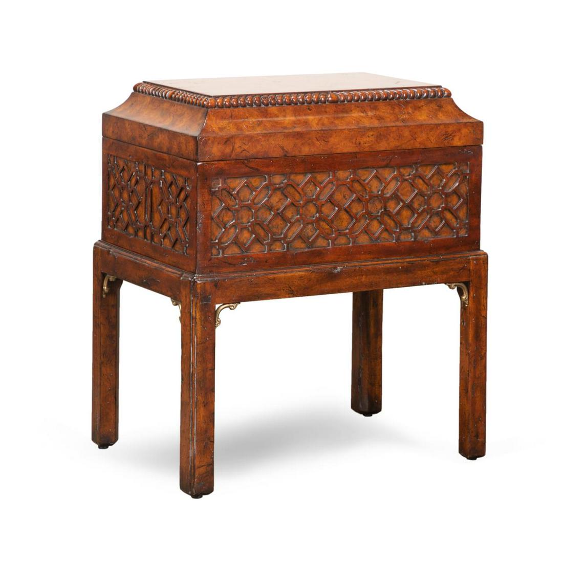 THEODORE ALEXANDER BURL WOOD CHEST ON STAND: Theodore Alexander carved burl wood chest in the Chippendale taste, having blind fretwork, and rising on straight legs, label to the interior. Approximate dimensions: h. 25", w. 22", d. 15".