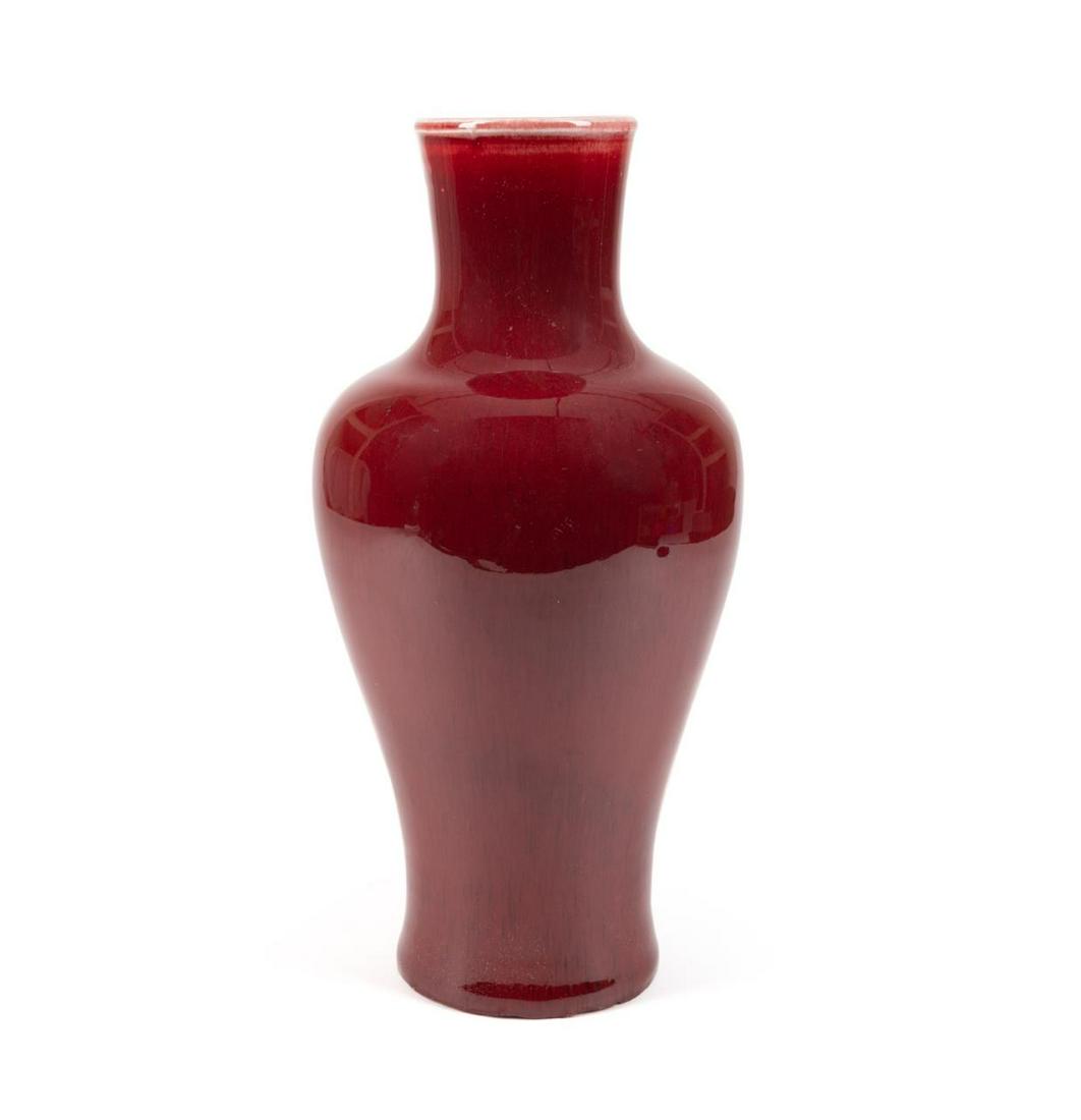 CHINESE SANG DE BOEUF GLAZED BALUSTER VASE: Chinese Sang de Boeuf glazed baluster vase, having a slightly flared neck above a tapering shouldered form with allover oxblood glaze, having no apparent marks. Approximate dimensions: h. 13", dia. 5.