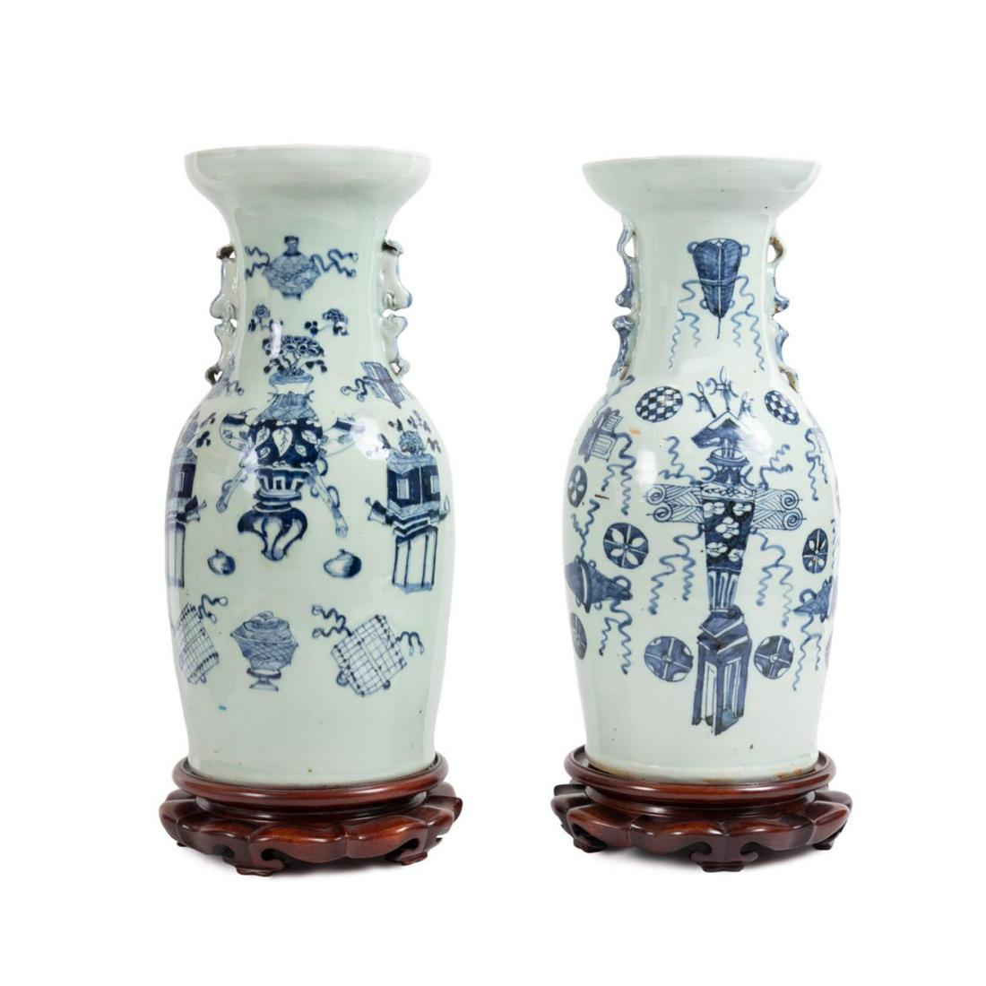 PR CHINESE BLUE & WHITE ON CELADON VASES, STANDS: Pair of Chinese blue and white on celadon vases, having trumpet necks with dished rims and Fu lion handles, above barrel form bodies decorated with 'bogu' or ancient things, having no apparent marks,