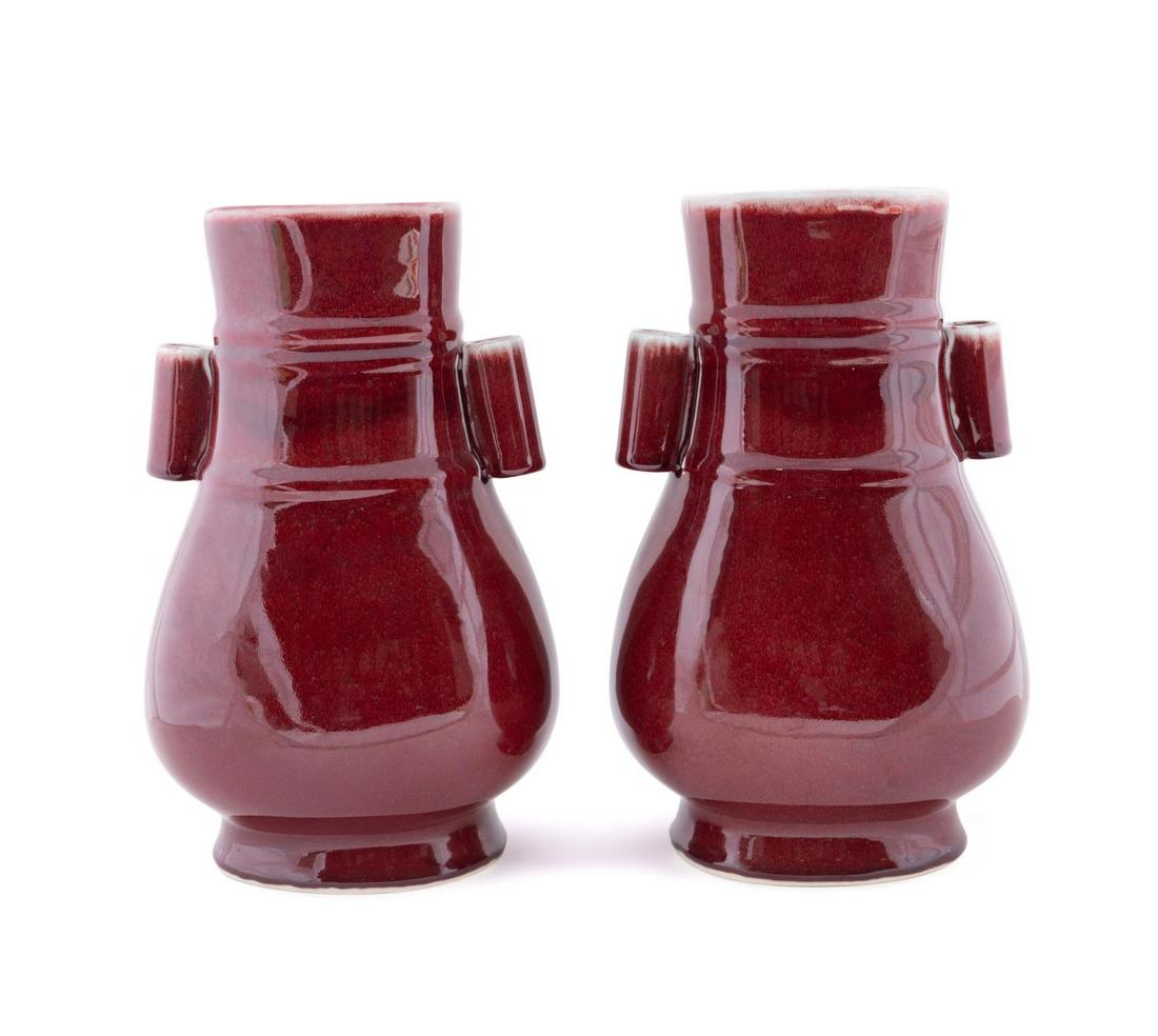 PAIR CHINESE SANG DE BOEUF HU VASES: Pair of Chinese Sang de Boeuf Hu vases, having cylinder handles and all over oxblood glaze, with no apparent marks. Approximate dimensions: h. 11.20", w. 6.25", d. 5.5".
