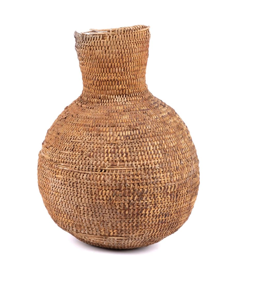 APACHE COILED BASKETRY WATER JUG, LATE 19TH CEN: Apache coiled basketry water jug, late 19th century, constructed of coiled grasses covered in pine resin or pitch, having a long cylinder neck above a globular body, with vestiges of horsehair that wo