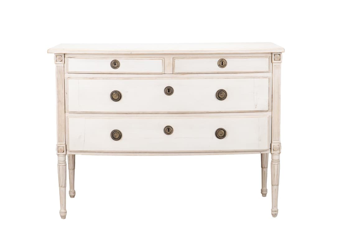 E. 20TH C. SWEDISH GUSTAVIAN PAINTED COMMODE: Swedish pine bow front commode in the Gustavian taste, early 20th century, having a distressed creamy white painted finish, two short drawers above two long drawers, and rising on fluted tapering legs