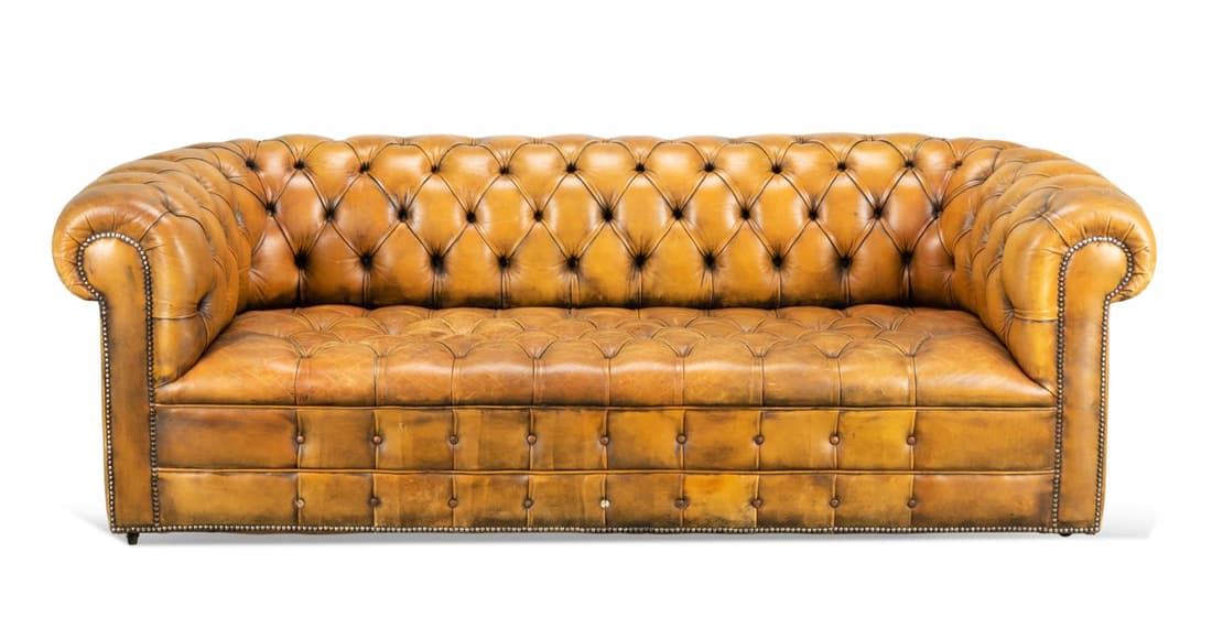 LIGHT BROWN LEATHER TUFTED CHESTERFIELD SOFA: Light brown leather tufted Chesterfield sofa, having a rolled back and arms, rising on casters, having no apparent marks. Approximate measurements: h. 27. 5", w. 80", d. 35"; seat h. 15. 5".