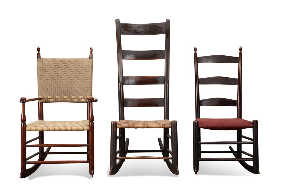 THREE AMERICAN SHAKER STYLE ROCKING CHAIRS: Group of three American wooden rocking chairs in the Shaker taste comprising, a ladderback chair with natural woven seat, a ladderback chair with acorn finials and red woven seat, and an armchair with