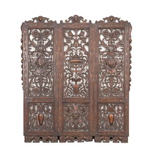 CONTINENTAL PIERCE CARVED WOOD THREE PANEL SCREEN: Continental pierce carved wood three panel floor screen, having a center crest with a carved female mask flanked by cabochon crests, the central panel having a pierced vase and scrolling acanthus with