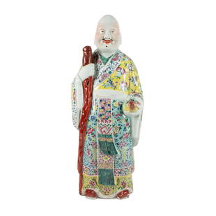 CHINESE FAMILLE ROSE SHOU XING FIGURE: Chinese Famille Rose figure of Shou Xing, one of the three Star Gods, depicted standing wearing an Imperial yellow robe covered in peaches and Shou characters, denoting longevity, holding the peach of