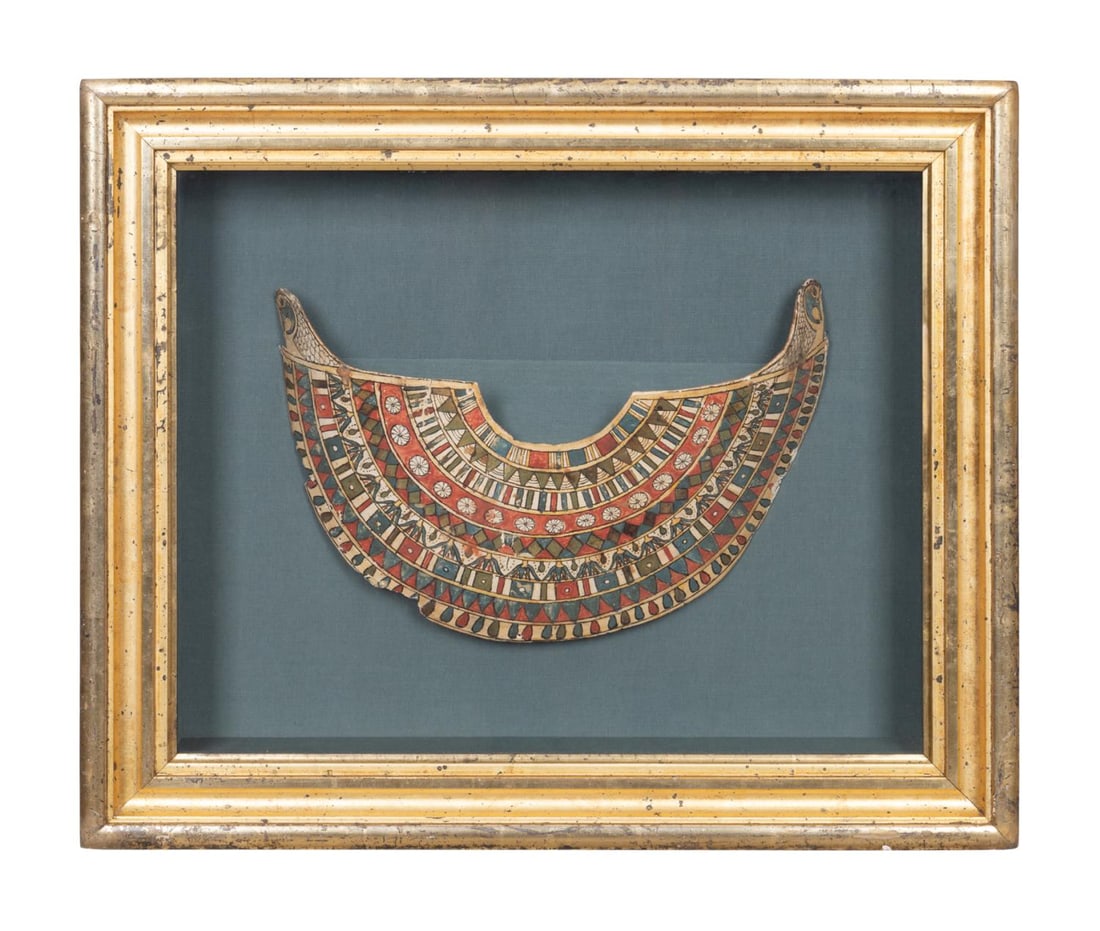 EGYPTIAN CARTONNAGE BROAD COLLAR NECKLACE: Egyptian cartonnage broad collar necklace, in papyrus, gesso, and pigment, having falcon head terminals issuing bands of flowers, papyrus blossoms, and geometric decorations in the manner of an actual
