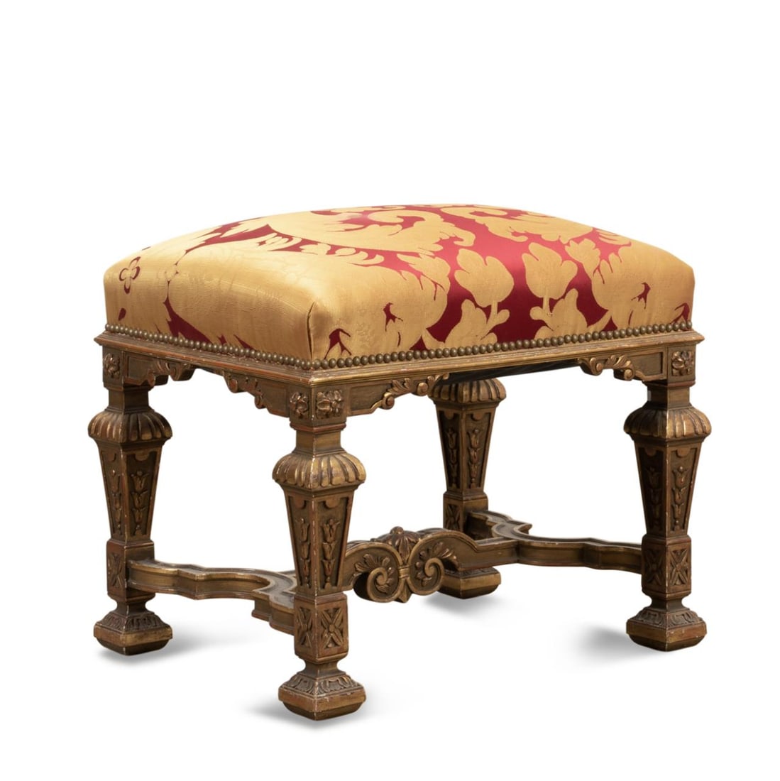 19TH/20TH C. LOUIS XIV STYLE GILTWOOD TABOURET: Continental giltwood tabouret or footstool in the Louis XIV taste, late 19th to early 20th century, having red and gold damask Scalamandre type upholstery, and rising on baluster legs with stretcher, 