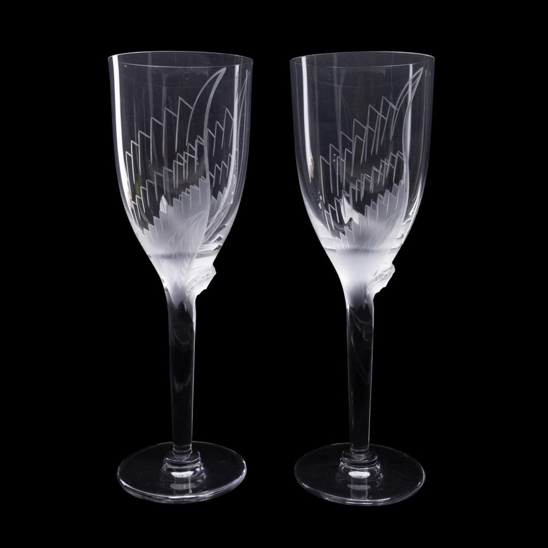 PR LALIQUE FRANCE ANGEL PATTERN CHAMPAGNE GLASSES: Pair of Lalique France 'Angel' pattern champagne glasses, each having a frosted decoration with a shaped head and etched wings, having acid etched maker's mark to underside of foot. Approximate dimens