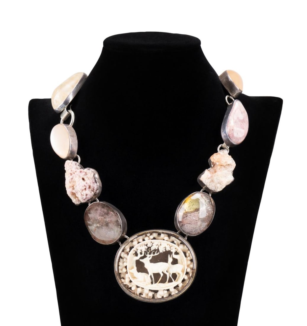 REBECCA COLLINS STONE, BONE & STERLING NECKLACE: Rebecca Collins stone, bone, and sterling necklace, centering an oval glass shadow box locket containing an antique German carved bone scene of deer in a forest, flanked by garden quartz, rose quartz,