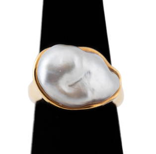 ELSA PERETTI FOR TIFFANY BAROQUE PEARL & 18K RING: Modernist Elsa Peretti for Tiffany & Co. baroque pearl and 18k yellow gold ring, having an approximately 19mm by 13mm by 6mm cultured South Sea silver baroque pearl set transverse in a free form high