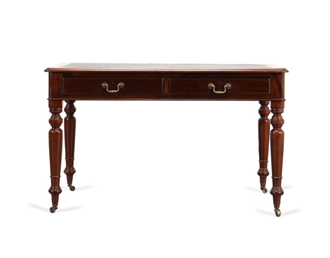 GEORGE IV MAHOGANY LEATHER TOP DESK, L. 19TH C.: English George IV or Victorian mahogany desk, late 19th century, having a molded top with a black leather inset, over two drawers and raised on turned legs with casters, apparently unmarked. Approxima