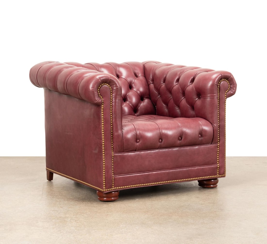 BURGUNDY LEATHER CHESTERFIELD CHAIR: Chesterfield easy chair, having burgundy upholstery, tufted rolled back and arms, brass nailhead trim, tight seat, and rising on bun feet, manufacturer's tag to the underside. Provenance: From the Est