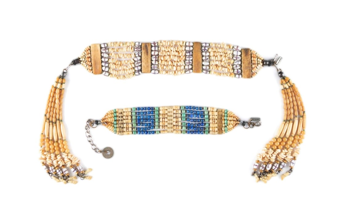 TWO MASHA ARCHER BONE, GLASS & STONE CHOKERS: Masha Archer. Two bone, glass, and stone chokers comprising, a seven-strand choker with detachable tassels terminating to carved bone hands; together with a seven strand choker having bone, lapis, and