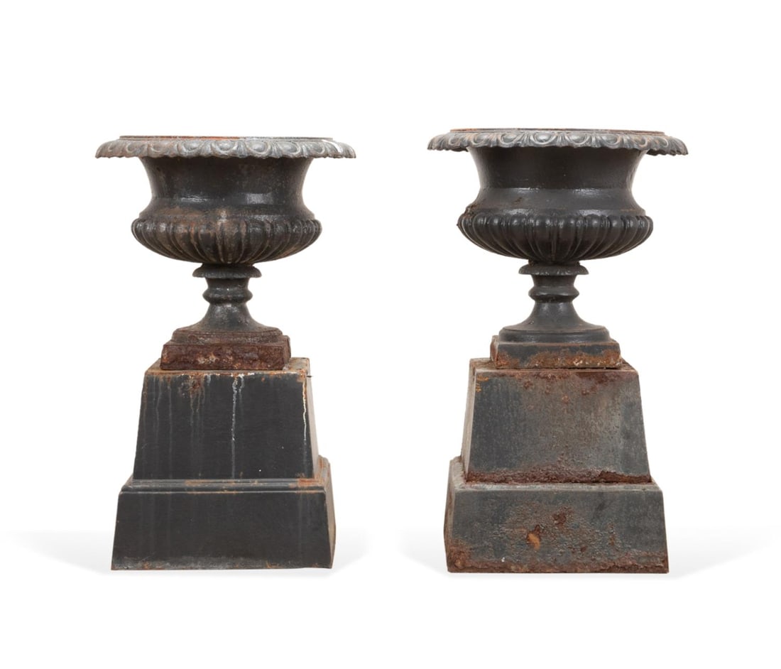 PAIR GADROONED CAST IRON GARDEN URNS ON BASES: Pair of American or English cast iron garden urns, 20th century, each having a campagna form, egg and dart rim, gadrooned body on socle plinth, and on a spreading base, apparently unmarked. Approximat