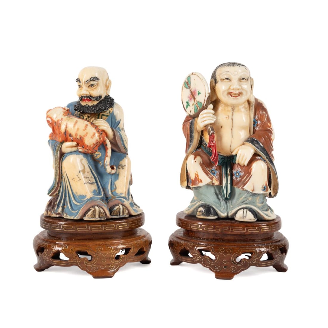 TWO CHINESE PAINTED BONE BUDDHIST FIGURES: Two Chinese paint decorated carved bone Buddhist figures comprising, a laughing Buddha having an urna on his forehead and elongated earlobes, depicted seated, holding a fan; and Vijraputra, one of the