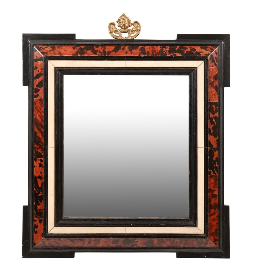 CONTINENTAL BAROQUE STYLE SHELL VENEER MIRROR: Continental, 20th century. Parcel ebonized, bone inlaid, and shell veneer cushion mirror in the Baroque style, having a bronze putto mount, apparently unmarked. Approximate dimensions: h. 18.25", w. 1
