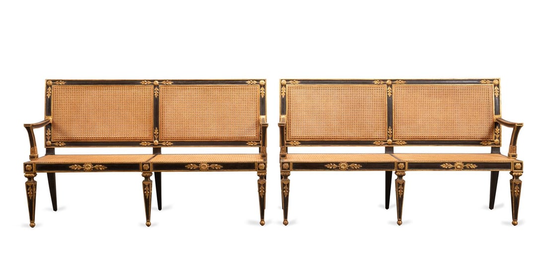 PR NEOCLASSICAL GILT & BLACK PAINTED CANED SETTEES: Italian. Pair of Neoclassical style black and parcel gilt painted settees, having a rectangular frame with caned back and seat, and raised on tapered square legs with gold ball feet, apparently unmark