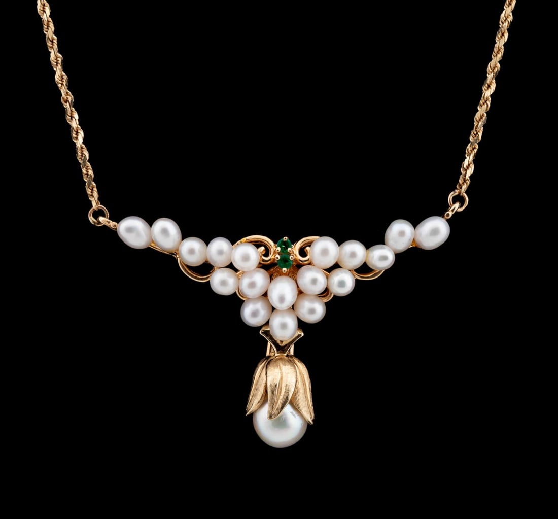CULTURED PEARL AND EMERALD BIB-STYLE NECKLACE: Cultured pearl and emerald bib-style necklace in 14k yellow gold, with (18) freshwater pearls, (2) approximately 2mm brilliant cut emeralds, and a bell cap freshwater pearl drop. Marked '14k' to clasp