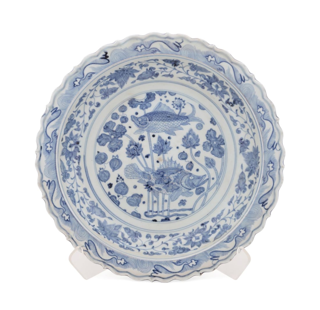 CHINESE BLUE AND WHITE CHARGER: Chinese. Large blue and white charger with scalloped rim, depicting wave patterns and center fish motifs, apparently unmarked. Approximate dimensions: h. 3.25", dia. 18".