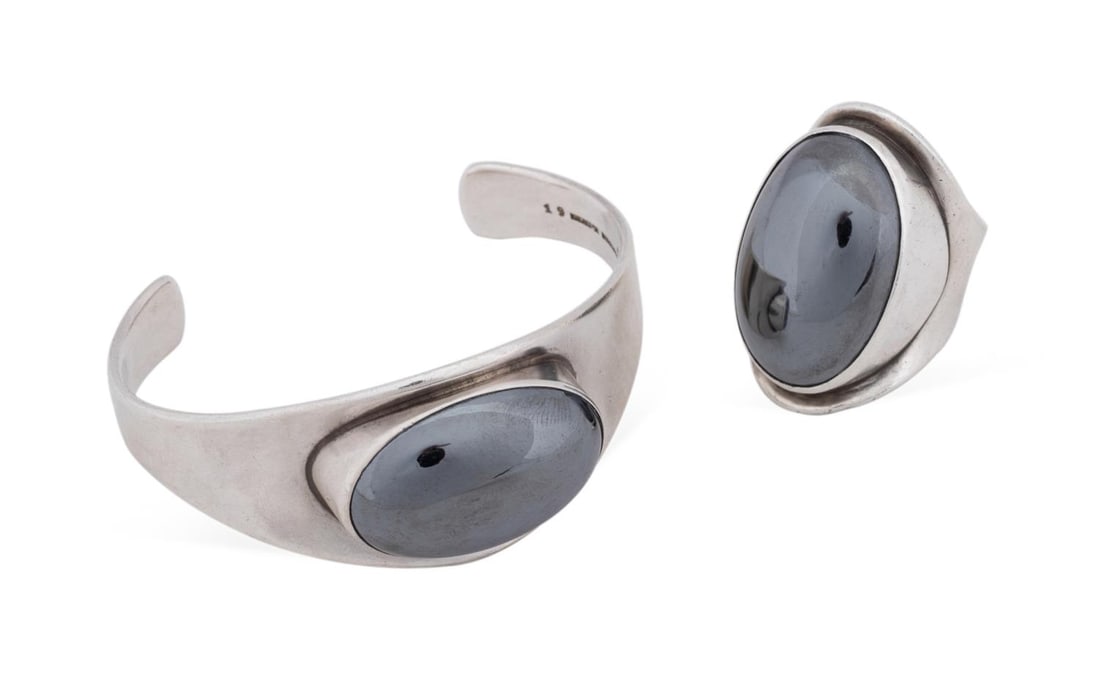BENT KNUDSEN DANISH HEMATITE STERLING JEWELRY SET: Bent Knudsen (Danish, born 1924). Modernist hematite and sterling silver jewelry set comprising one cabochon cocktail ring, with an open band, and one cabochon tapered cuff bracelet, one marked "Bentk