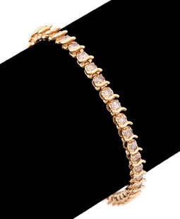 DIAMOND TENNIS BRACELET SET IN 14K YG: Diamond tennis bracelet with (42) round brilliant cut diamonds weighing approximately 4.40 total carats (I-2 clarity and light brown color) terminating in a tension clasp / safety bar, set in 14k yell