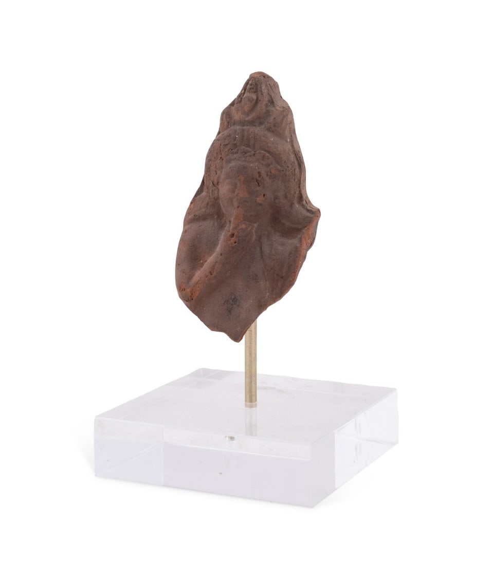 EGYPTIAN TERRACOTTA HEAD OF HARPOCRATES, 2ND C. BC: Egyptian, 2nd century BC. Harpocrates terracotta head on acrylic stand, depicting finger to mouth. Note: Accompanied by M.S. Rau Inc appraisal, 1986. Provenance: Private Collection of Alton Arnall Tho