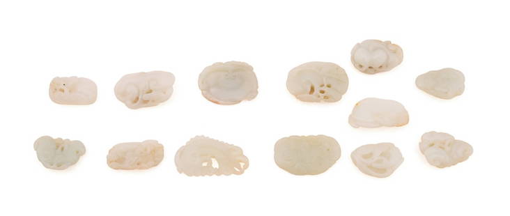 13 HETIAN JADE MINIATURE CARVINGS, CLOUDS & WAVES: Chinese. 13 pieces of Hetian jade carvings of auspicious motifs, including clouds and sea-wave motifs, the stone of celadon to pale gray tone with occasional russet skin, apparently unmarked. Private