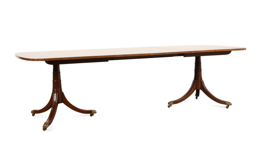 KITTINGER MAHOGANY PEDESTAL DINING TABLE, 2 LEAVES: Kittinger Company (American, founded 1866), 20th century. Mahogany dining table in the Duncan Phyfe / Federal taste, pattern number 0113, having ring turned canon-form double pedestal, and rising on d