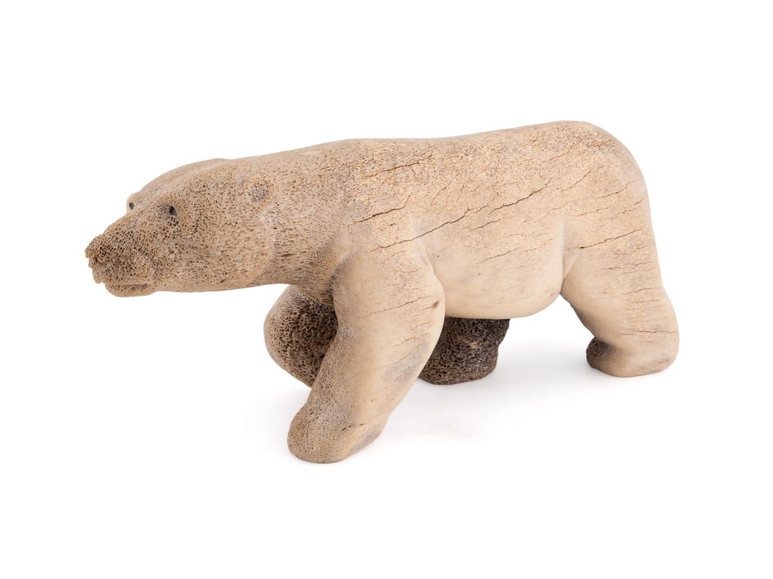 KENT HEINDEL FOSSILIZED BONE POLAR BEAR: Kent Heindel (American (Alaska), born 1962). Inuit fossilized bone carved polar bear sculpture, signature "Kent Heindel" to lower foot. Provenance: Private Collection of Dannette Duckworth, Atlanta, G