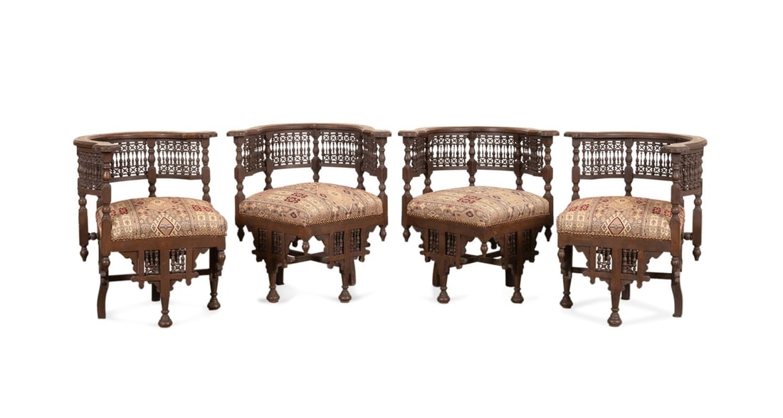 SET OF FOUR SYRIAN MOP INLAID CORNER CHAIRS: Syrian, early 20th century. Set of four wooden corner chairs in the Moorish taste, having mother of pearl and bone inlay, turned spindlework, and rising on bun feet, apparently unmarked. Provenance: P