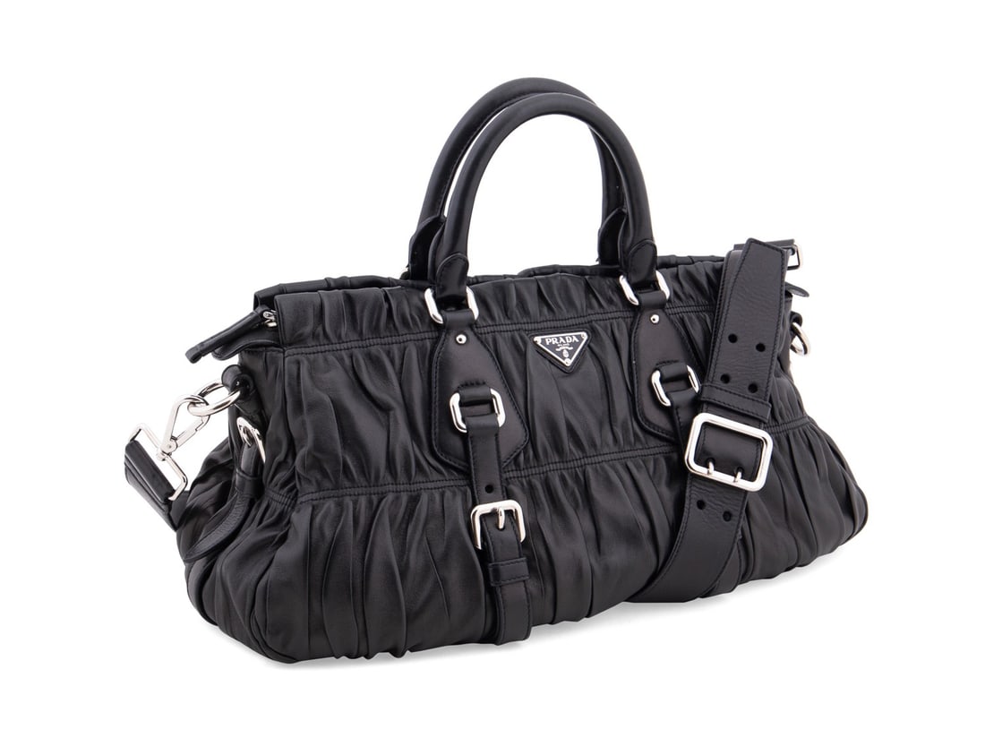 PRADA BLACK NAPA LEATHER GAUFRE HANDBAG: Prada (Italian, founded 1913). Black gathered napa leather Gaufre handbag with silver toned hardware, two top handles, and branded canvas lining. Accompanied by original Barney's tag, removable crossb